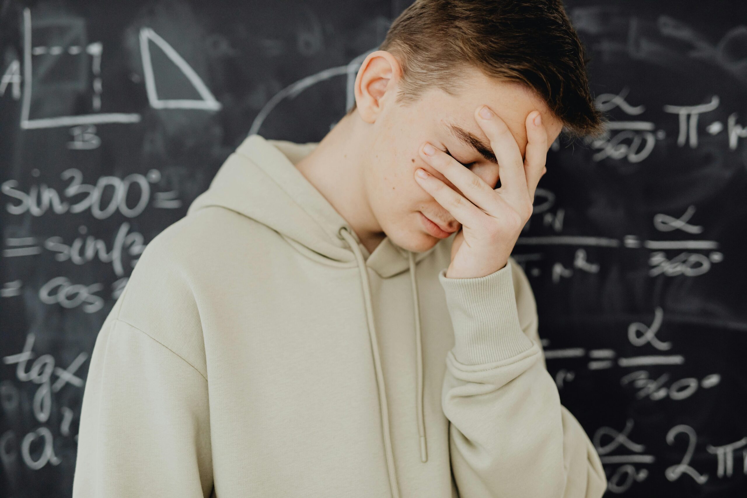 Image showing a student struggling with a large graphing calculator during an exam.