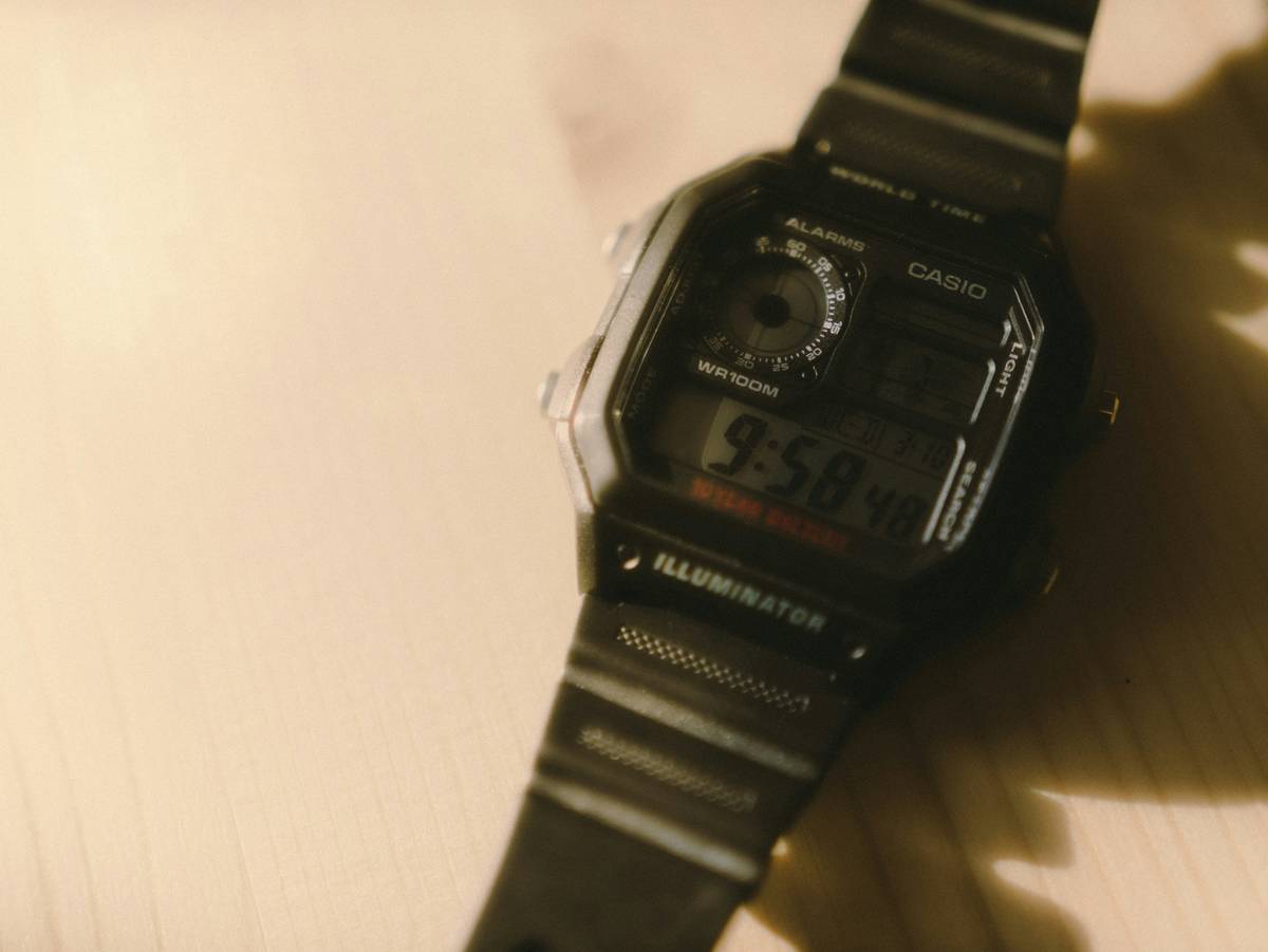 A sleek silver watch calculator on a desk