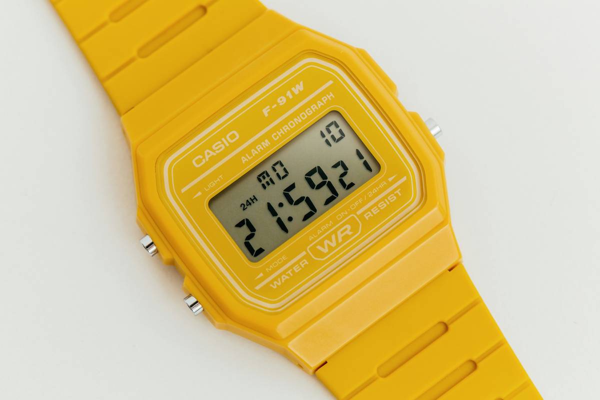 Comparison image showing a slim non programmable watch next to a bulky smartphone