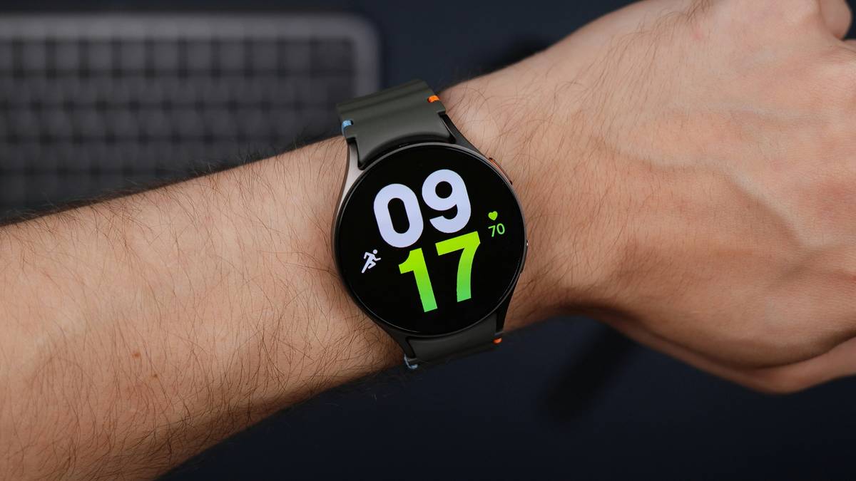 A professional wearing a watch calculator while working on financial sheets.