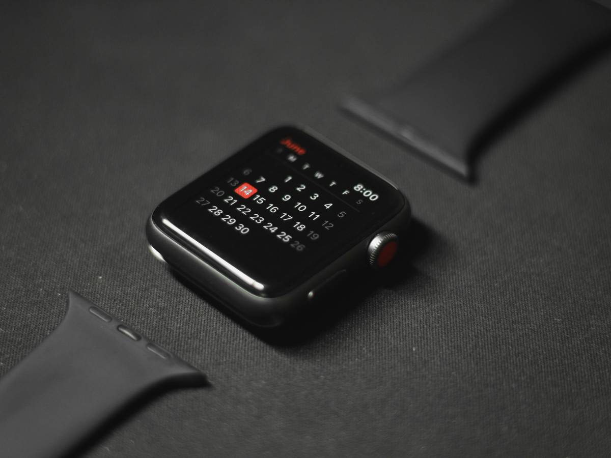 Person wearing watch calculator typing on laptop for maximum productivity